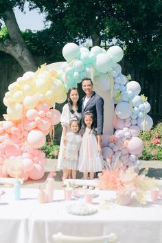 a family posing for a photo in front of balloons