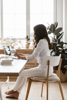 a woman sitting at a desk using a laptop computer