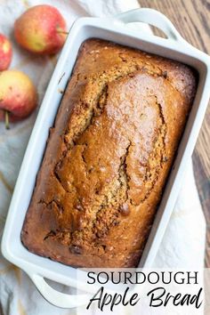 a loaf of sourdough apple bread in a pan with apples on the side