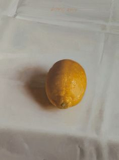 an orange sitting on top of a white table cloth