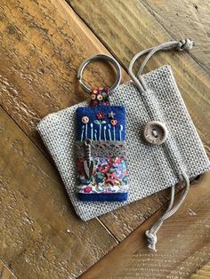 a small purse sitting on top of a wooden floor next to a pair of scissors