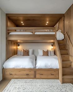 two beds in a room with wooden stairs