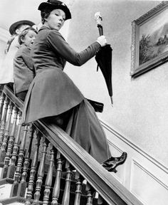 an old photo of two women on the stairs with umbrellas over their heads,