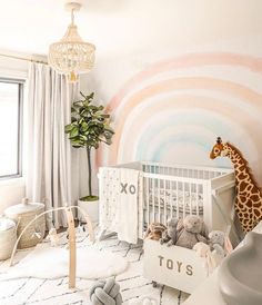 a baby's room with a giraffe mural and toys in the crib