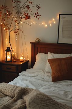 a bed with white sheets and blankets in front of a window filled with lights, candles and a tree branch