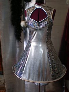 a silver dress on display in front of a mirror