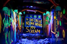 the tunnel is covered in graffiti and neon lights