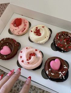 six cupcakes in a box with hearts and sprinkles on them