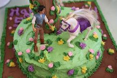 a birthday cake decorated with toy horses and flowers