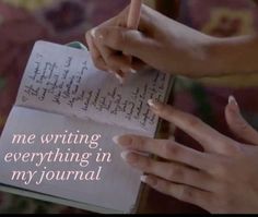 two hands holding a pen and writing something in a book with the words me writing everything in my journal