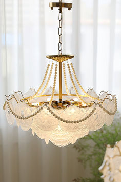 a chandelier hanging from a ceiling in a room with white walls and curtains