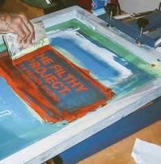 a person is painting on a large piece of paper