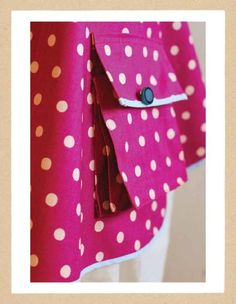 a close up of a pink polka dot jacket with buttons on the front and back