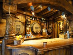 an old fashioned bar with wooden barrels hanging from it's ceiling and lights on the wall