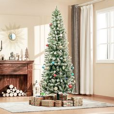 a christmas tree with presents under it in front of a fire place and fireplace mantel