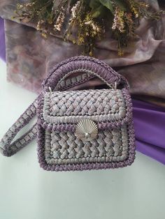 a small purse sitting on top of a table next to a purple cloth covered bag