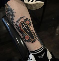 a person with a tattoo on their arm and foot is sitting in a black chair