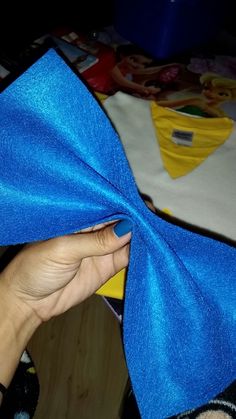 a person is holding a blue cloth over their left hand and the fabric has been folded