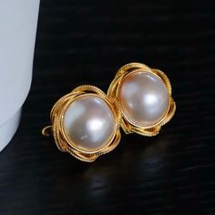 --- SPECIFICS --- 💚Materials: 100% Natural High Quality Mabe Pearl With 24k gold plated s925 Sterling silver 💚-The Mabe Pearl is 100% natural UNTREATED , UNHEATED, UNDYED Mabe Pearl- 💚Metal: Real 24k Gold plated s925 Sterling Silver 💚Pearl Diameter: 17mm*17mm 💚Closure: the closure is made of 925 Sterling Silver.  💚Handmade Artwork, original design and copyright protected💚 These stunning gold plated silver earrings feature a beautiful pair of hemisphere Mabe Pearl stones. With their intricate details and rich color, these push back studs are the perfect statement piece for any outfit. Handcrafted with care, these earrings are a true work of art and are sure to draw attention wherever you go. Whether you're looking for a unique gift or simply want to treat yourself. With their durable Fine Jewelry Clip-on Earrings For Wedding, Luxury Round Clip-on Earrings For Wedding, Yellow Gold Sterling Silver Pearl Earrings For Wedding, Wedding Yellow Gold Pearl Earrings In Sterling Silver, Wedding Yellow Gold Sterling Silver Pearl Earrings, Wedding Sterling Silver Clip-on Pearl Earrings, Wedding Fine Jewelry Clip-on Round Earrings, Wedding Clip-on Sterling Silver Pearl Earrings, Wedding Fine Jewelry Round Clip-on Earrings