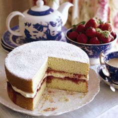 a cake on a plate with a slice cut out and strawberries in the background