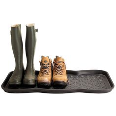 three pairs of boots sitting on top of a black tray with rubber feet and legs