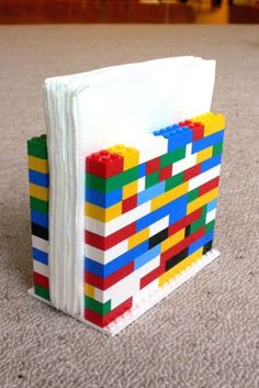 a book made out of legos sitting on the floor next to a pile of paper