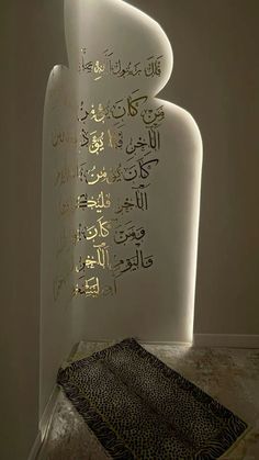 an illuminated sculpture in the corner of a room with arabic calligraphy written on it