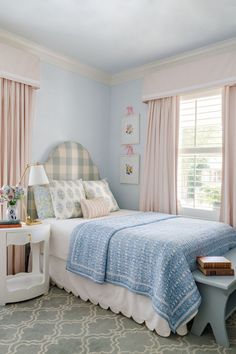 a bedroom with blue walls and pink curtains on the windowsills is decorated in pastel colors