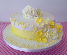 a white and yellow birthday cake with flowers on it