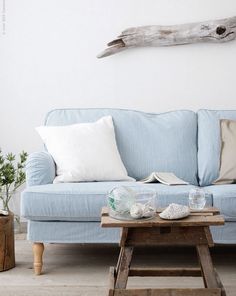 a blue couch sitting next to a wooden table