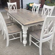 a wooden table with white chairs around it