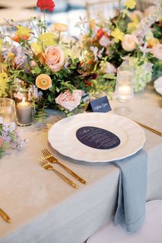 the table is set with flowers and candles for an elegant wedding reception or special event