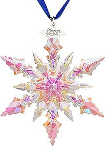 a colorful snowflake ornament hanging from a blue ribbon on a white background