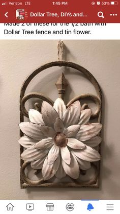 a white flower is hanging on the wall