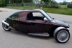 an unusual looking car is parked on the side of the road