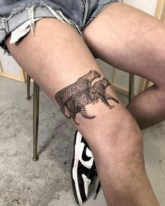 a woman's leg with an elephant tattoo on her left thigh and the bottom part of her legs