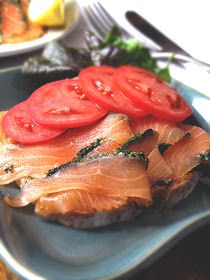 a plate with some meat and tomatoes on it