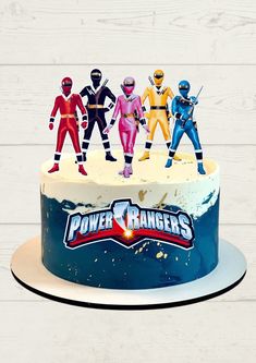 the power rangers cake is decorated with figurines and frosting on top of it