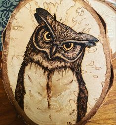 an owl painted on a piece of wood