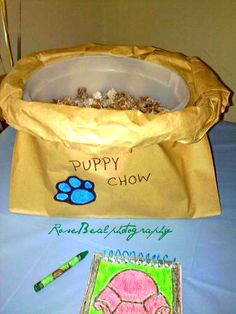 a dog's paw is on the table next to a paper bag with puppy chow written on it