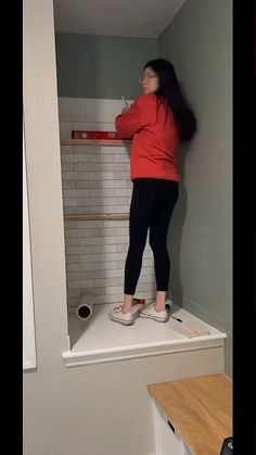 a woman standing on top of a bath tub