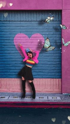 a woman standing in front of a garage door with a heart painted on the side