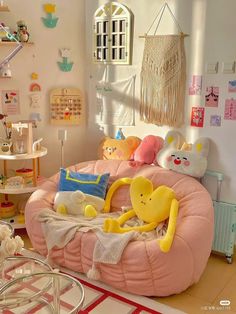 there is a pink bed with stuffed animals on it in the room that has many other toys