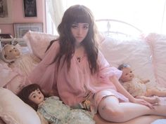 a woman sitting on top of a bed next to stuffed animals