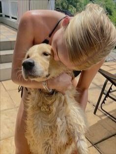 a woman is petting a dog on the porch