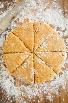 a wooden table topped with lots of food next to a knife and some powdered sugar