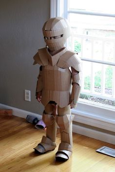 a cardboard robot standing in front of a window