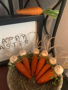 some carrots are sitting in a basket on a table next to a sign that says happy easter