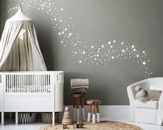 a baby's room with stars painted on the wall and a white crib