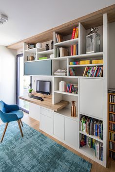 a living room with bookshelves and a chair in front of the window,